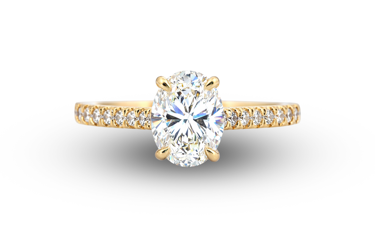 Gold ring with a large diamond and smaller diamonds on the band against a white background