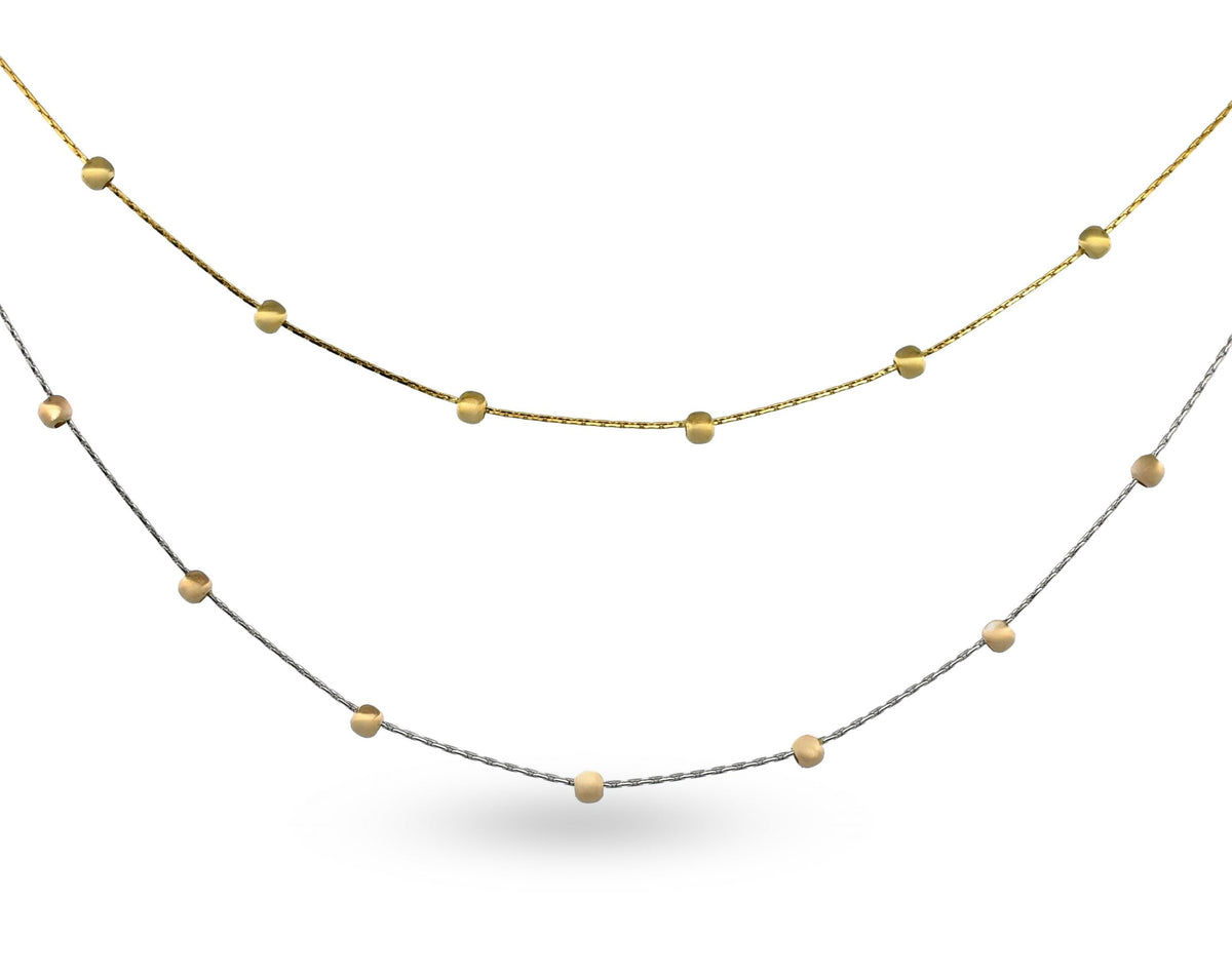 Two layered necklaces with gold and silver beads on a white background