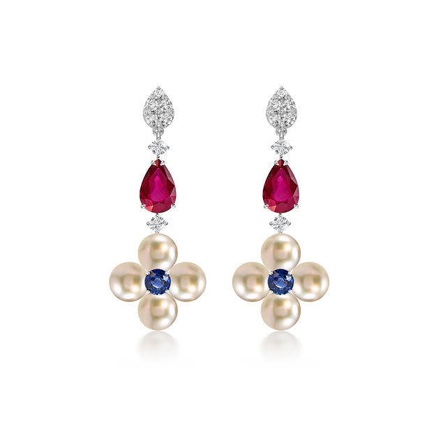 Pair of earrings with floral design featuring pearls, rubies, and sapphires on a white background.