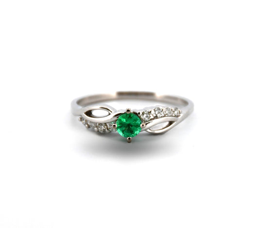 Silver ring with a green gemstone on a white background