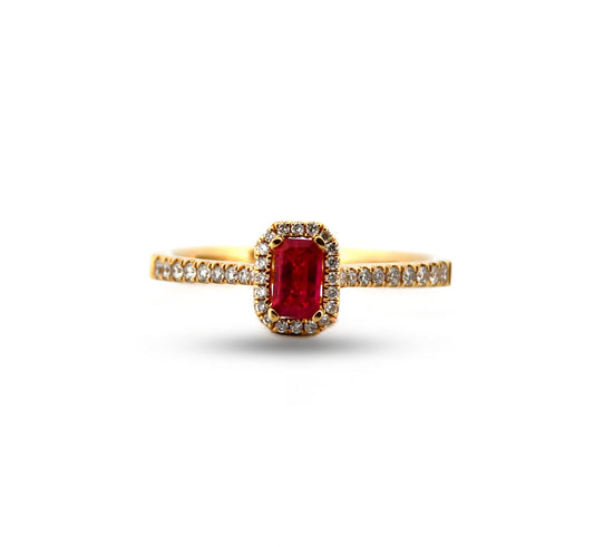 Gold ring with a red gemstone and diamond accents on a white background