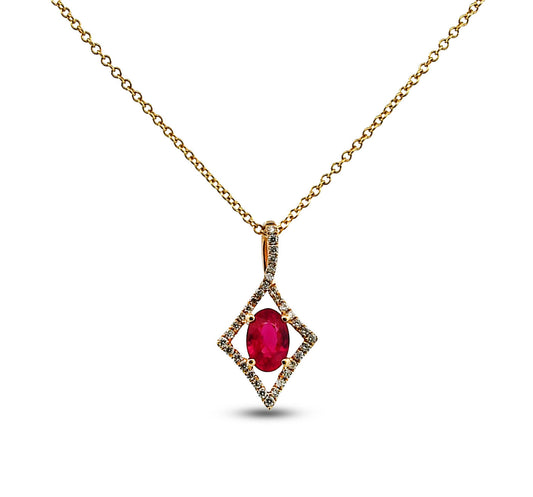 Gold necklace with a red gemstone pendant on a white background