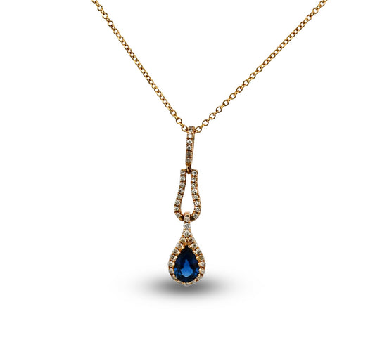Gold necklace with a blue teardrop pendant on a white background