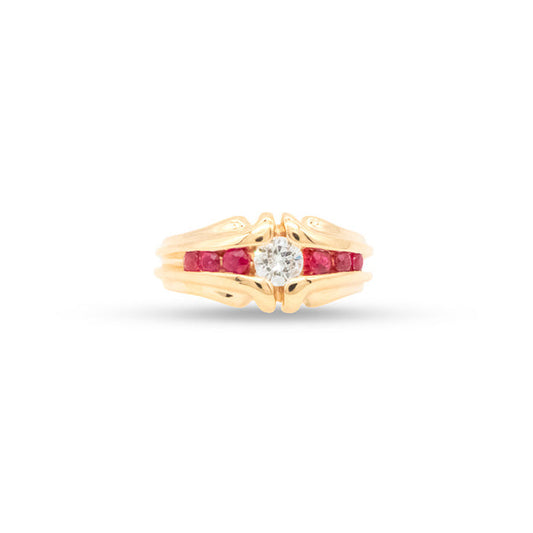 Gold ring with a central diamond and ruby stones on a white background