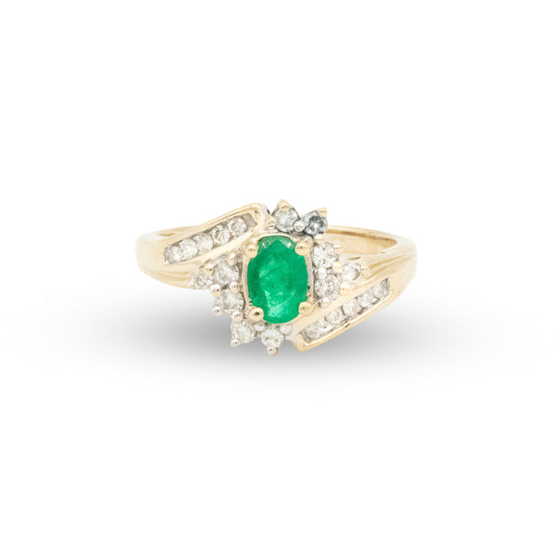 Gold ring with a green gemstone and diamonds on a white background