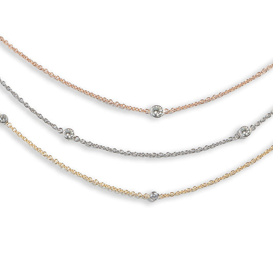 Three layered necklaces in gold, silver, and rose gold on a white background