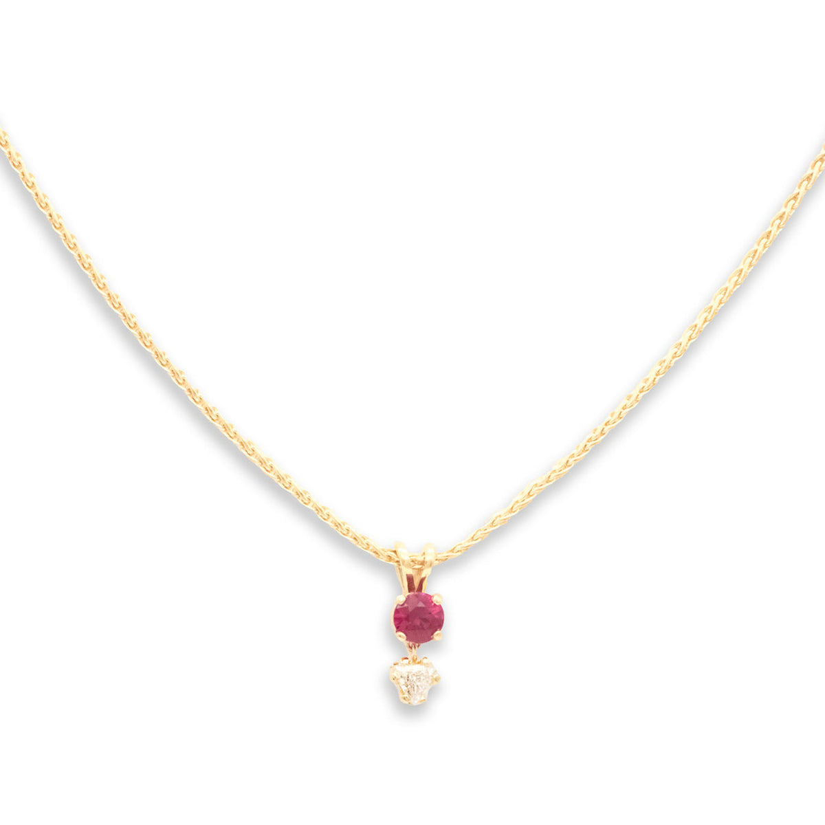 Gold necklace with a red gemstone pendant on a white background