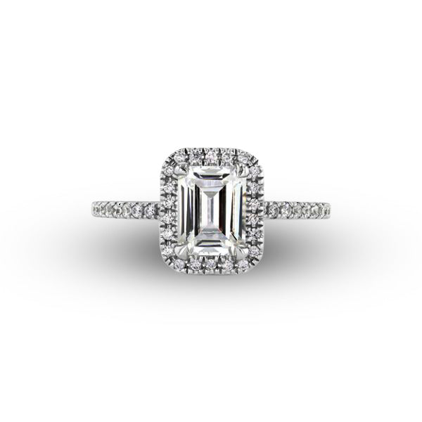 Diamond ring with emerald-cut center stone and halo on a white background
