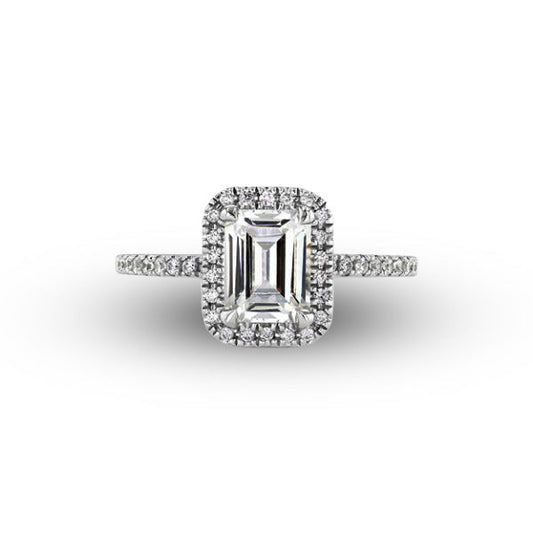 Diamond ring with emerald-cut center stone and halo on a white background
