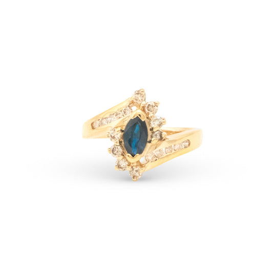 Gold ring with a blue gemstone on a white background