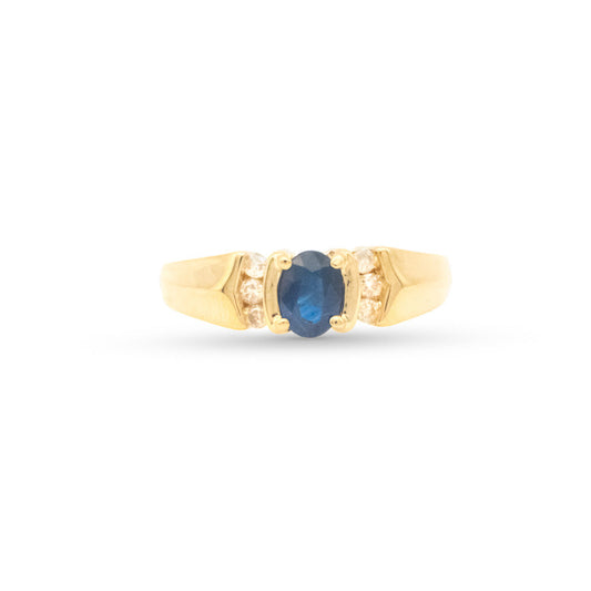 Gold ring with a blue gemstone on a white background
