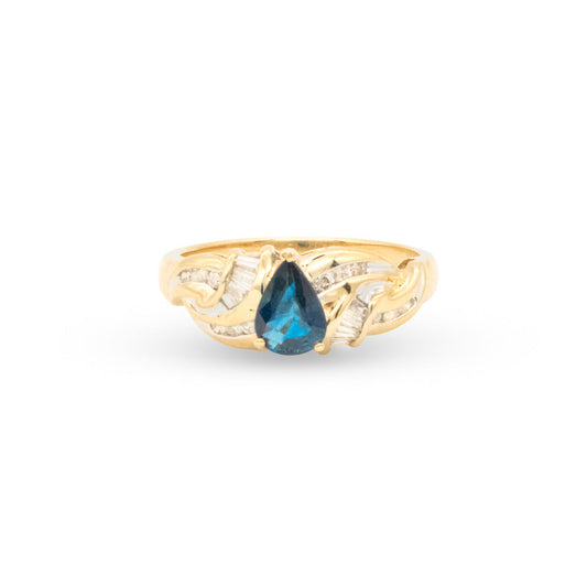 Gold ring with a blue gemstone on a white background