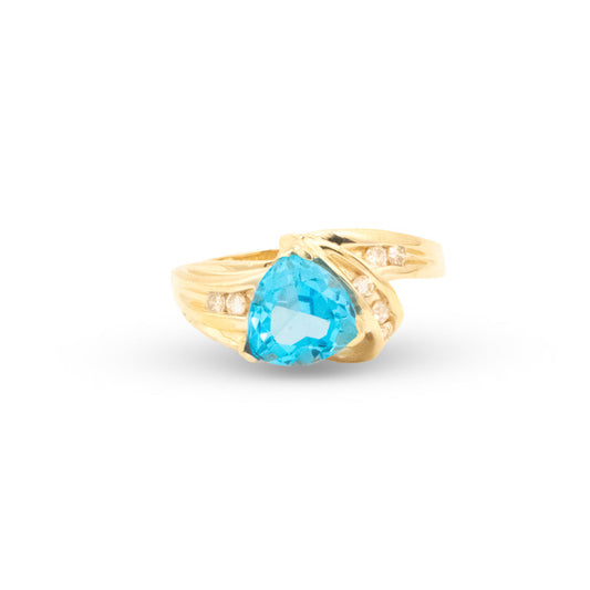 Gold ring with a blue gemstone on a white background